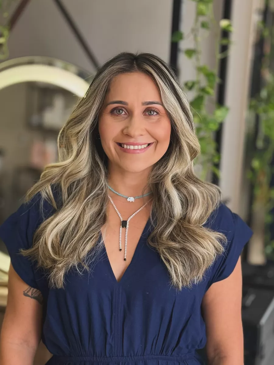 Cliente com cabelo loiro platinado iluminado e ondulado
