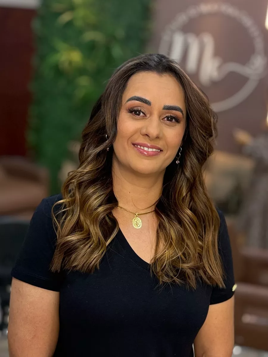 Cliente morena com cabelo ondulado e luzes em tom de mel