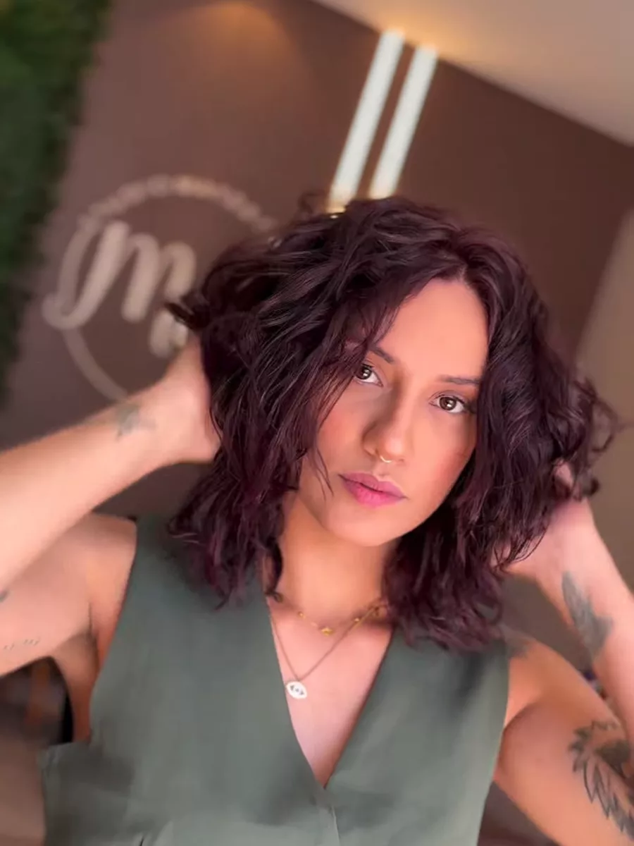 Cliente com cabelo ondulado curto em ruivo vinho